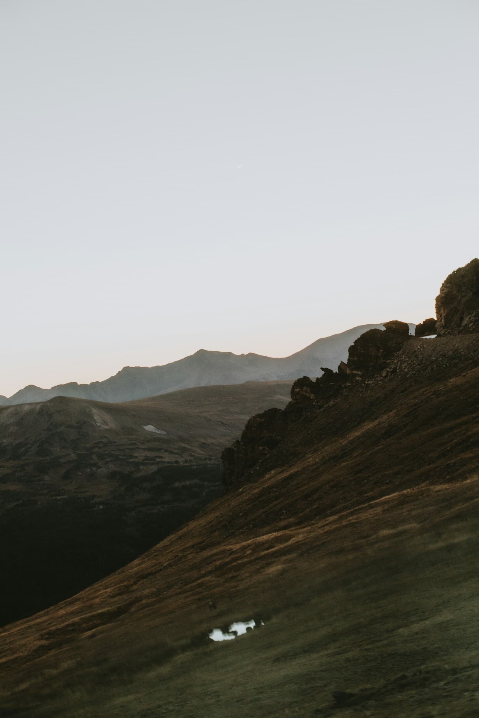 Grassy foothills fading into distant mountains