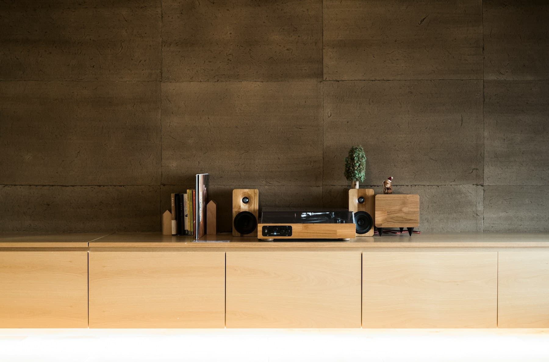 Turntable and small speakers on a low wooden sideboard