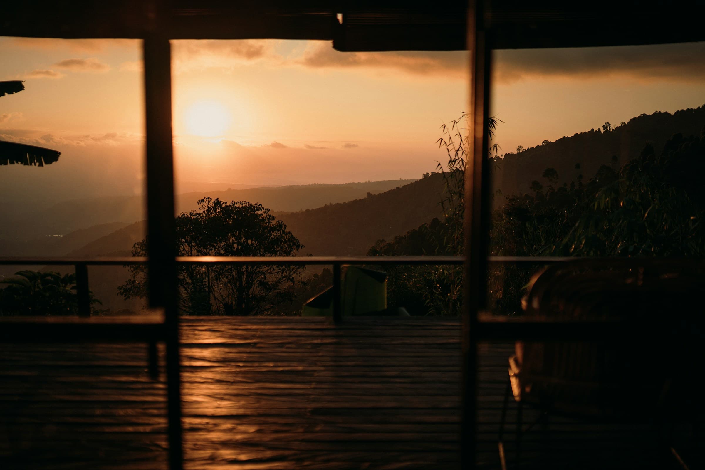 Sunset over the hills, framed by the windows of a terrace